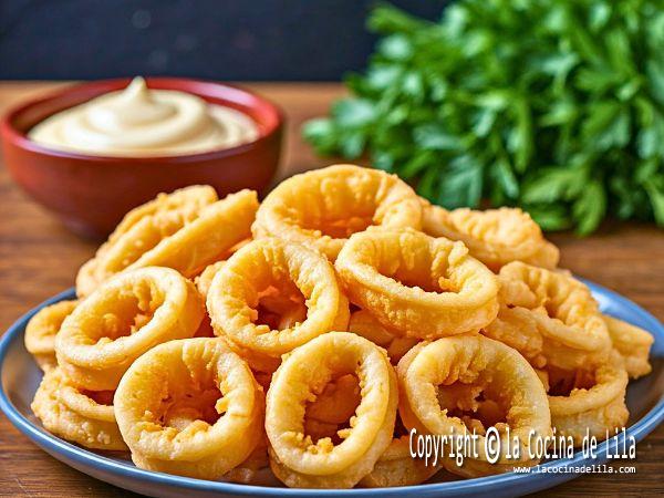 Calamares a la romana recién fritos servidos con rodajas de limón.