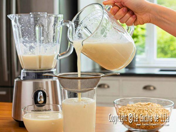 Pasos detallados para preparar leche de avena casera, incluyendo los ingredientes y el proceso.
