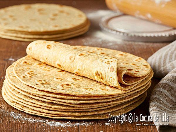 Tortillas de harina caseras recién hechas sobre una superficie rústica, listas para disfrutar.